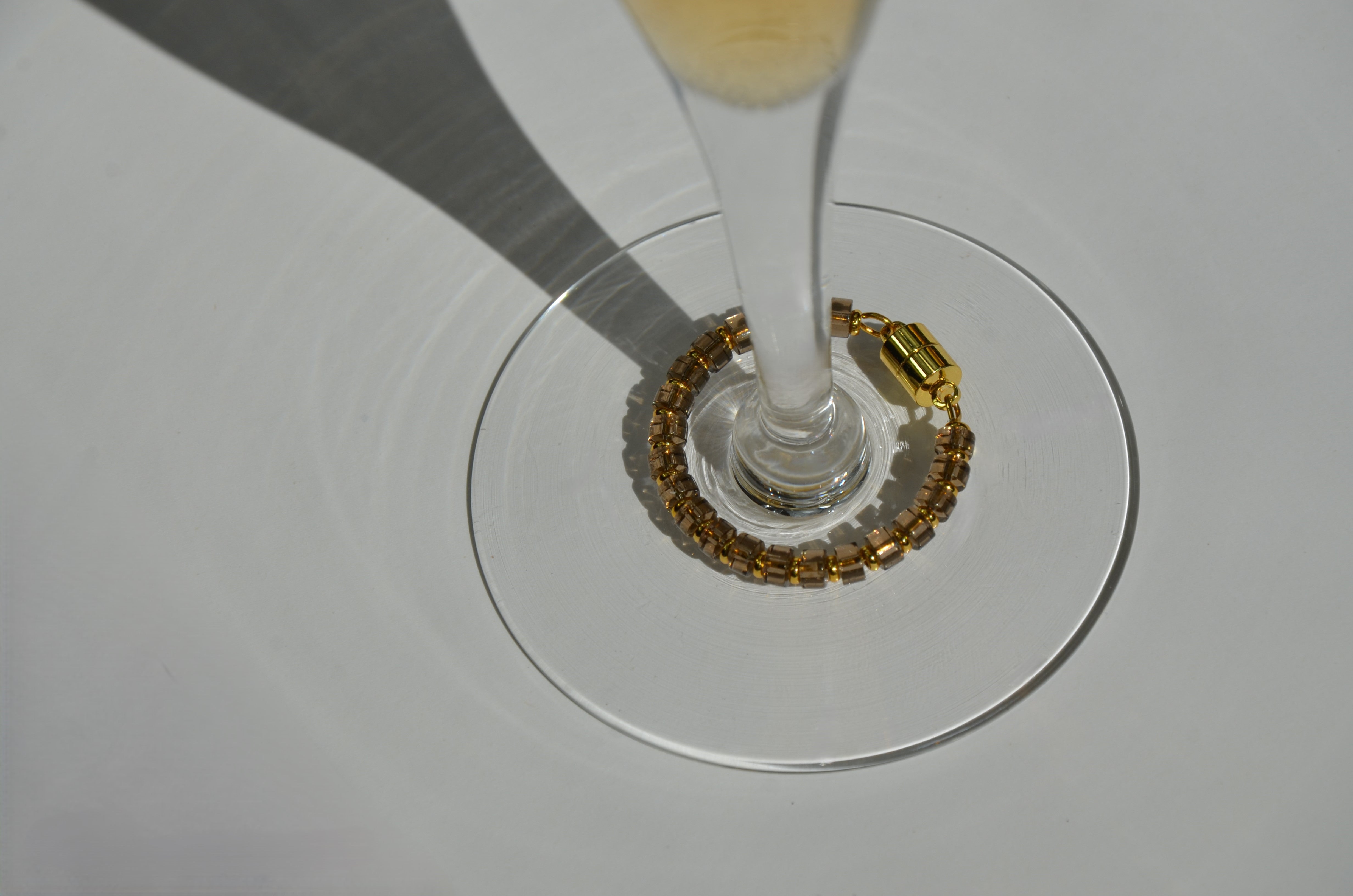 Close-up of a Smoky Quartz magnetic wine charm with gold hardware