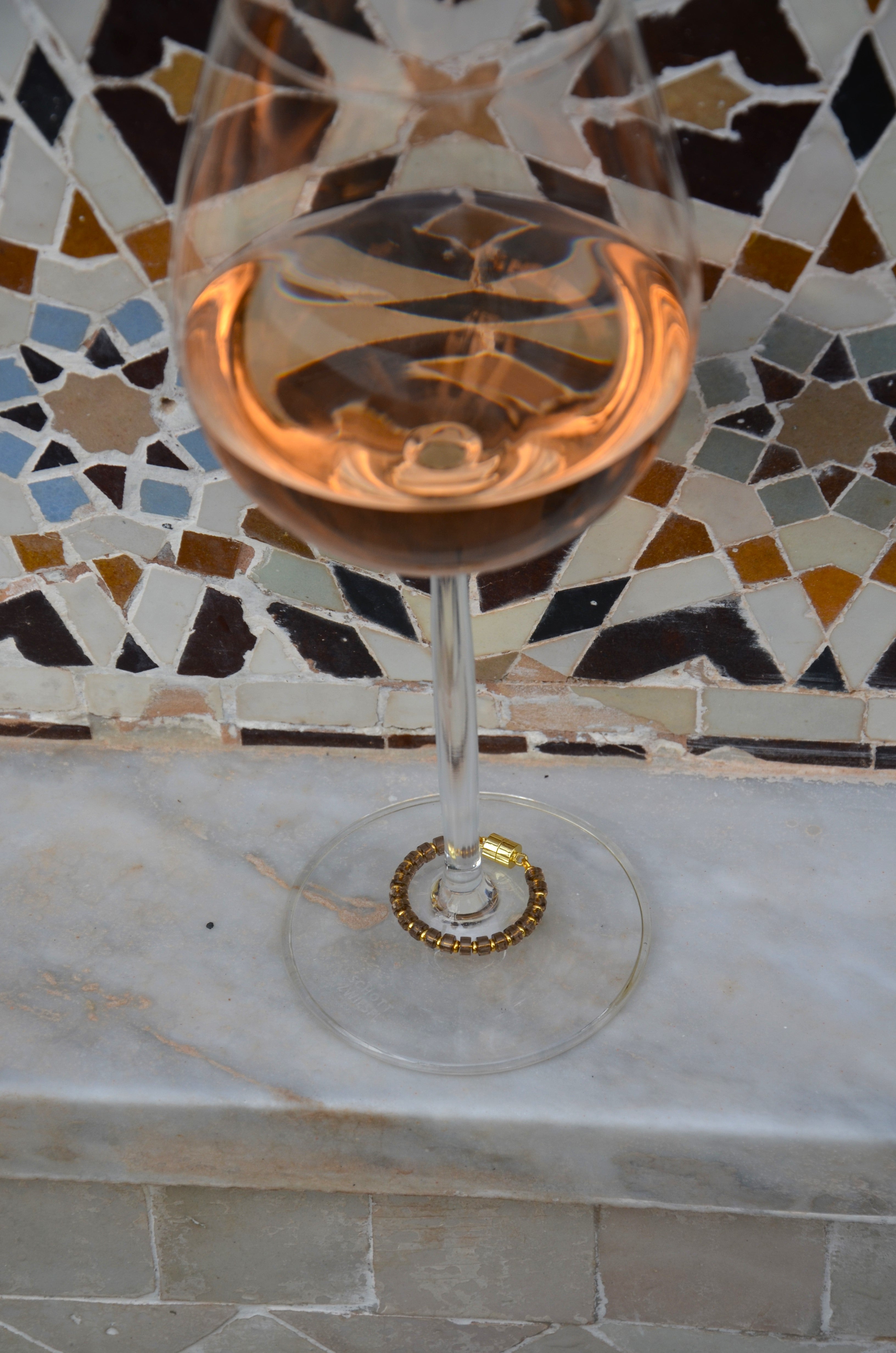 Smoky Quartz magnetic wine charm with gold hardware on a wine glass